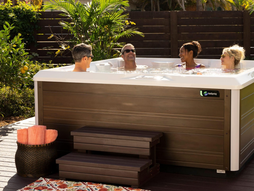 Friends enjoy a Hot Spring spa hot tub in their backyard.